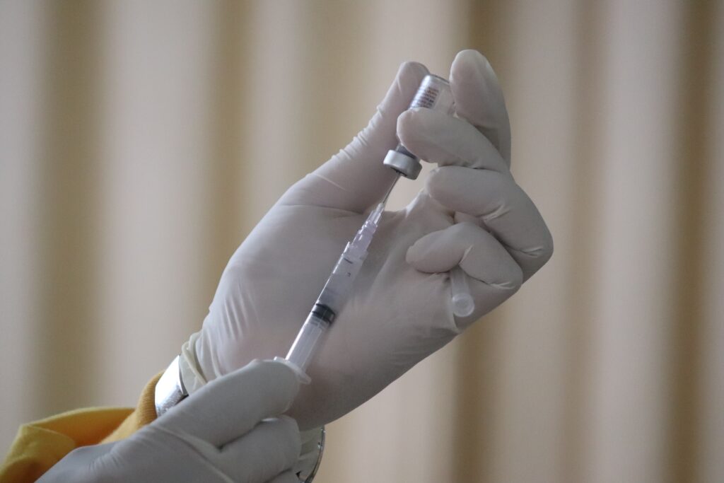 Person holds syringe and vial of drug.