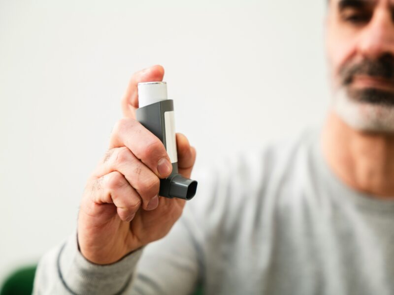 A man holds an asthma inhaler