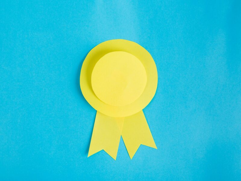 Yellow paper made ribbon on light blue background